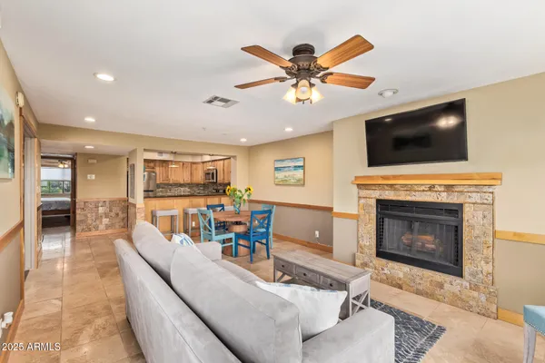 a living room with furniture a flat screen tv and a fireplace
