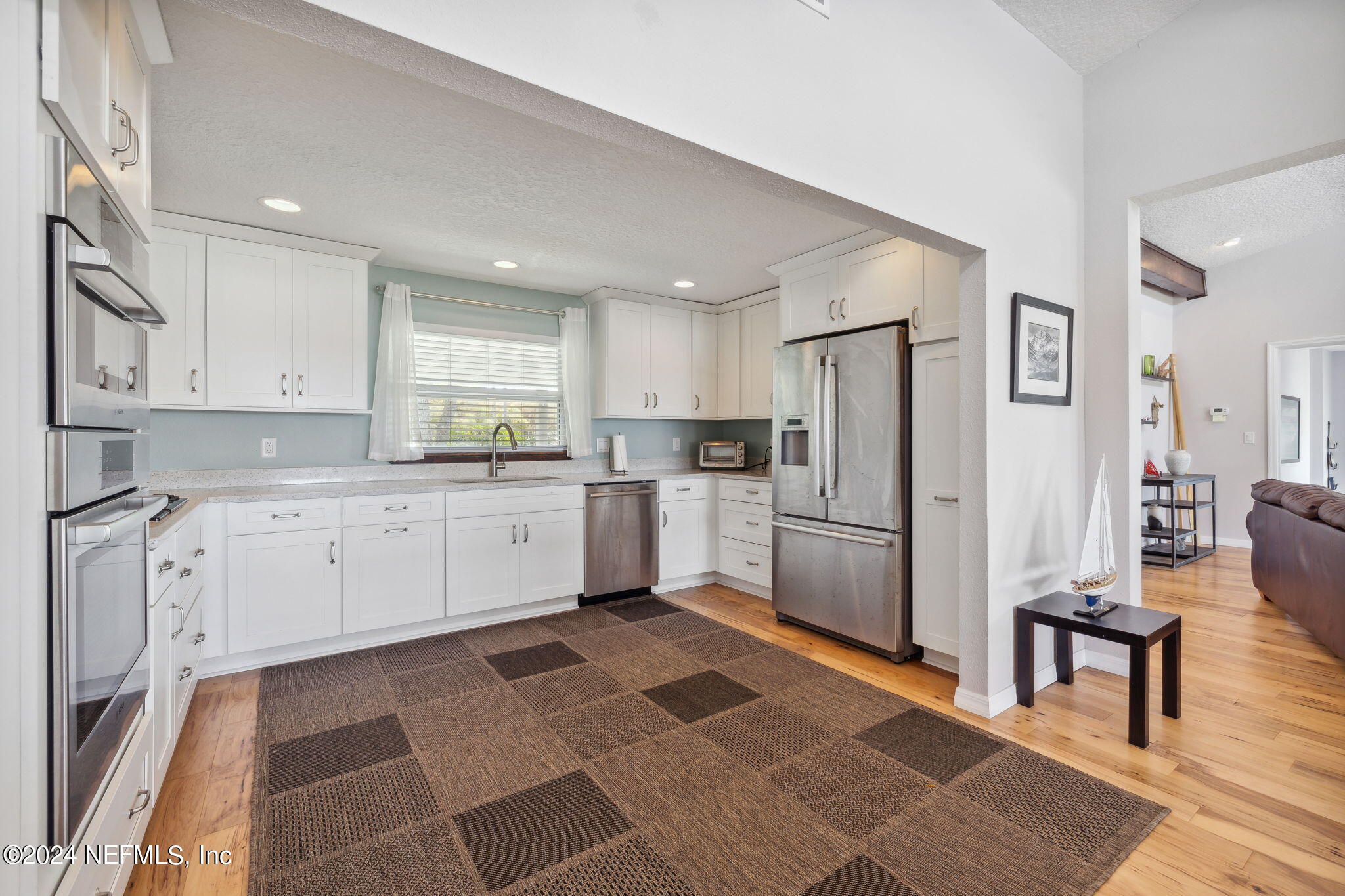 16045 Shellcracker Road Jacksonville, FL 32226 - Photo 12 of 40 a kitchen with white cabinets and stainless steel appliances