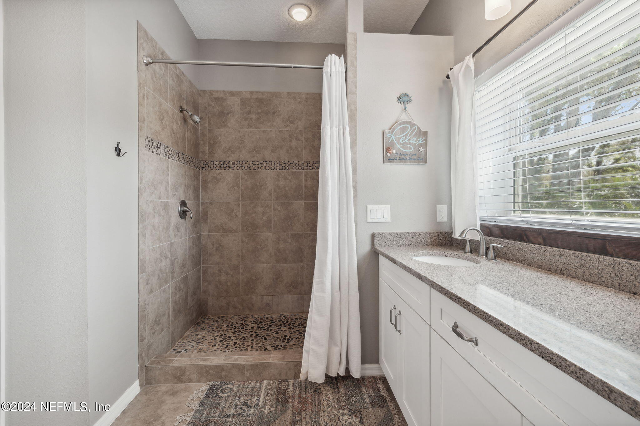 16045 Shellcracker Road Jacksonville, FL 32226 - Photo 19 of 40 a bathroom with a granite countertop sink a mirror a glass door a shower and vanity