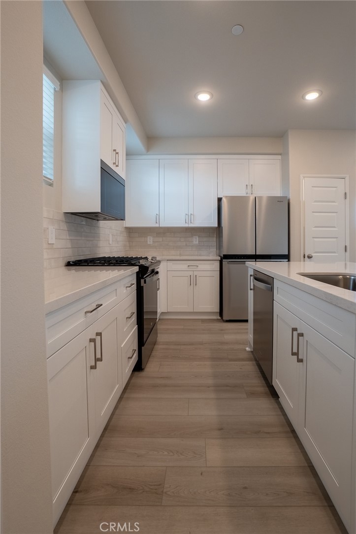 28586 Via Roble Temecula, CA 92591 - Photo 7 of 18 a kitchen with white cabinets and white appliances