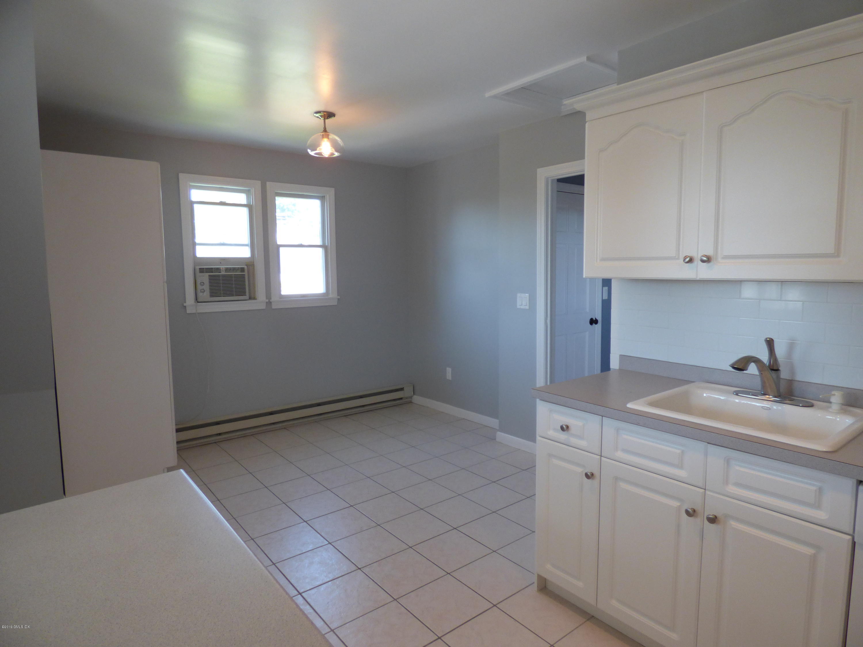 16 Lexington Avenue, Unit UPSTAIRS Greenwich, CT 06830 - Photo 5 of 12 a kitchen with a sink cabinets and window