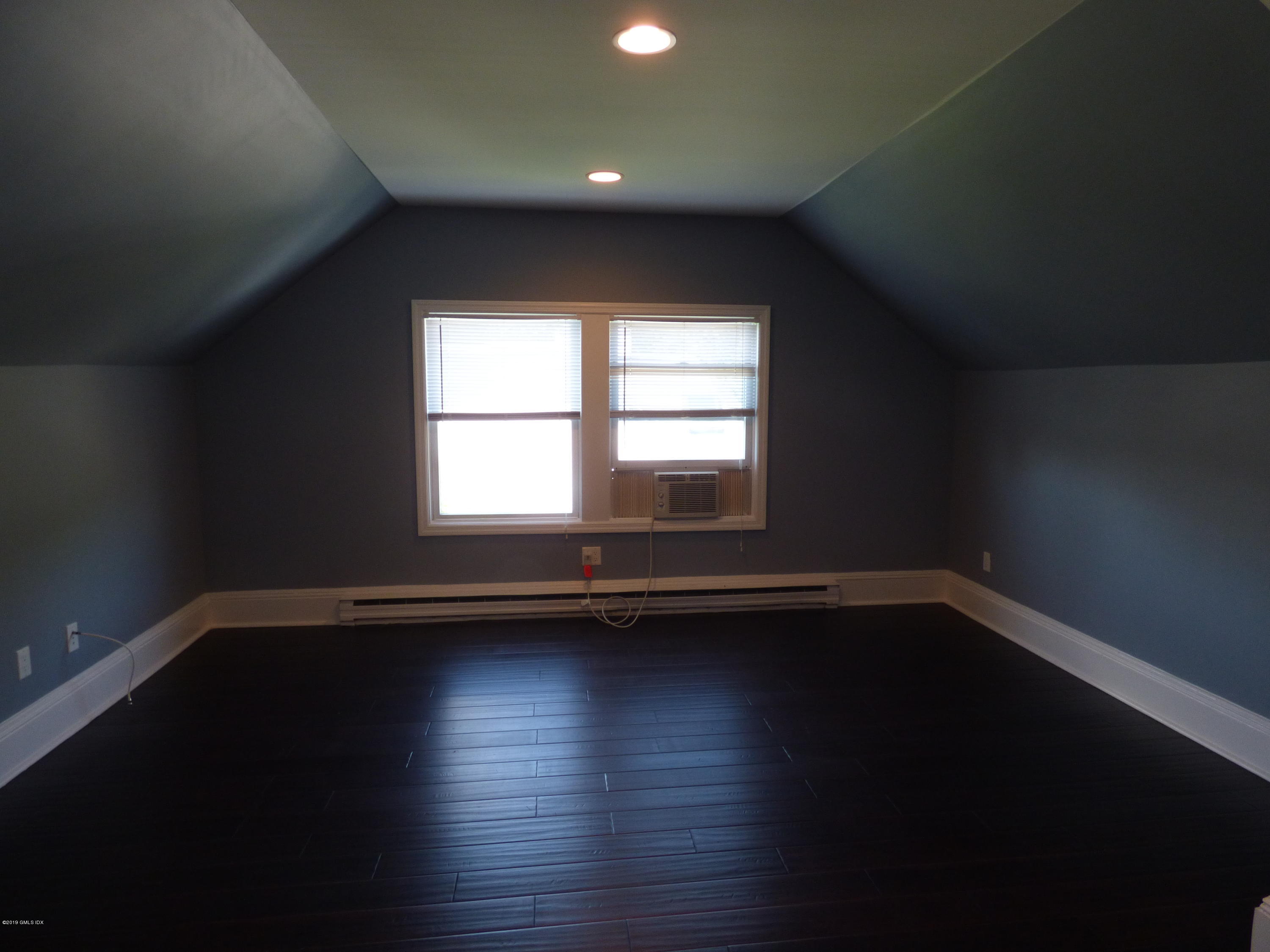 16 Lexington Avenue, Unit UPSTAIRS Greenwich, CT 06830 - Photo 6 of 12 a view of an empty room with wooden floor and a window