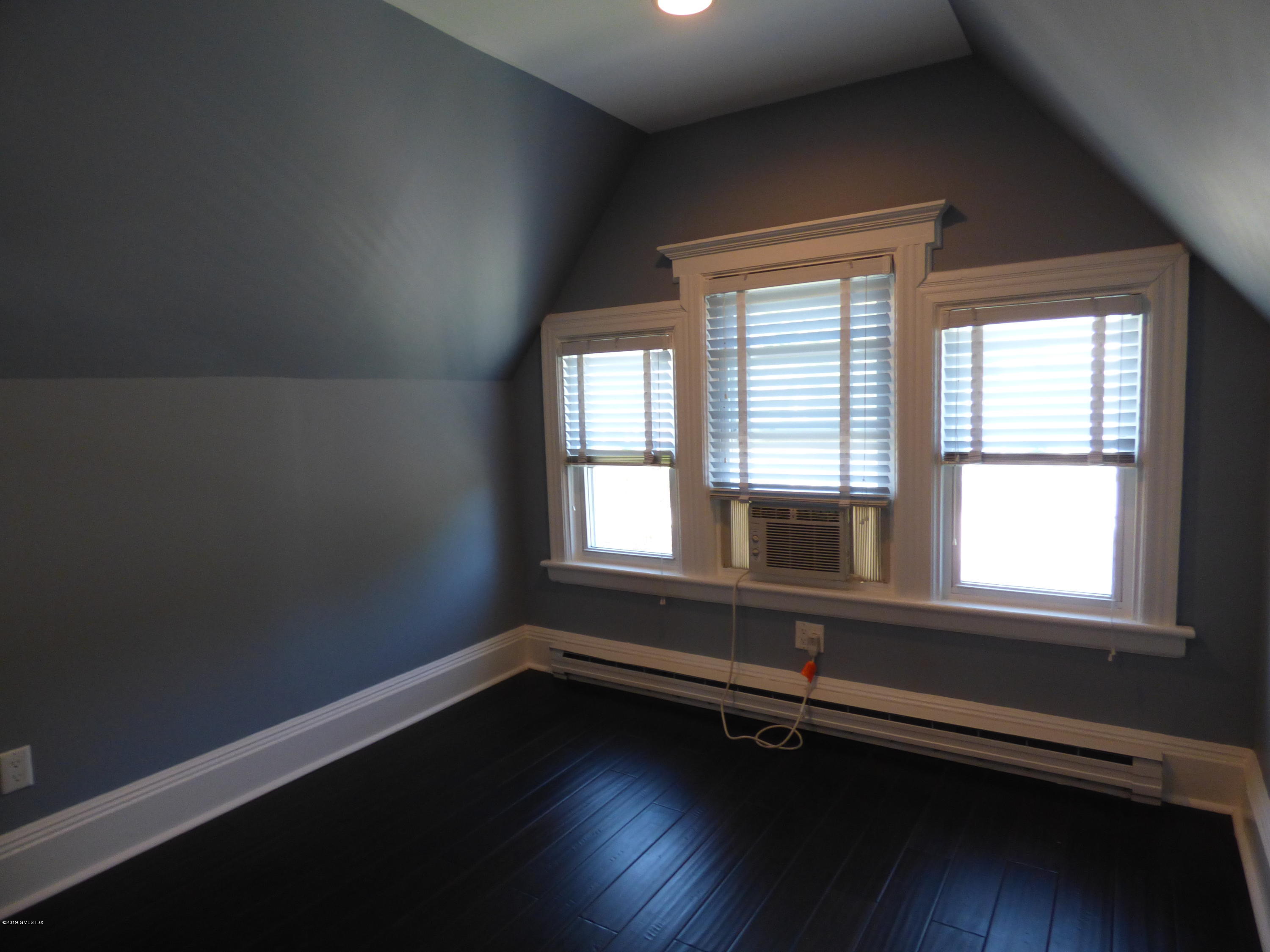 16 Lexington Avenue, Unit UPSTAIRS Greenwich, CT 06830 - Photo 8 of 12 an empty room with wooden floor and windows