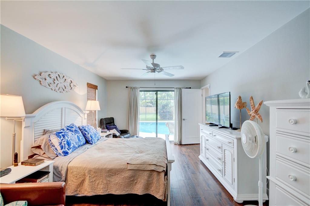 1139 Northwest Fork Road Stuart, FL 34994 - Photo 20 of 43 a bedroom with a bed and wooden floor