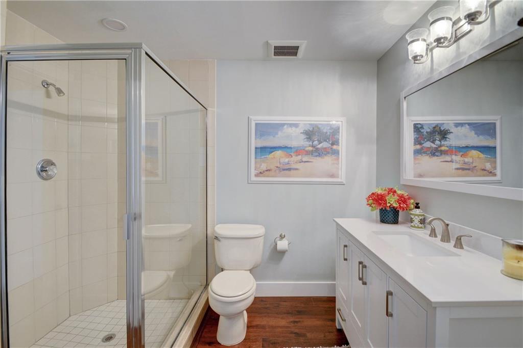 1139 Northwest Fork Road Stuart, FL 34994 - Photo 30 of 43 a bathroom with a toilet a sink a mirror a vanity and shower