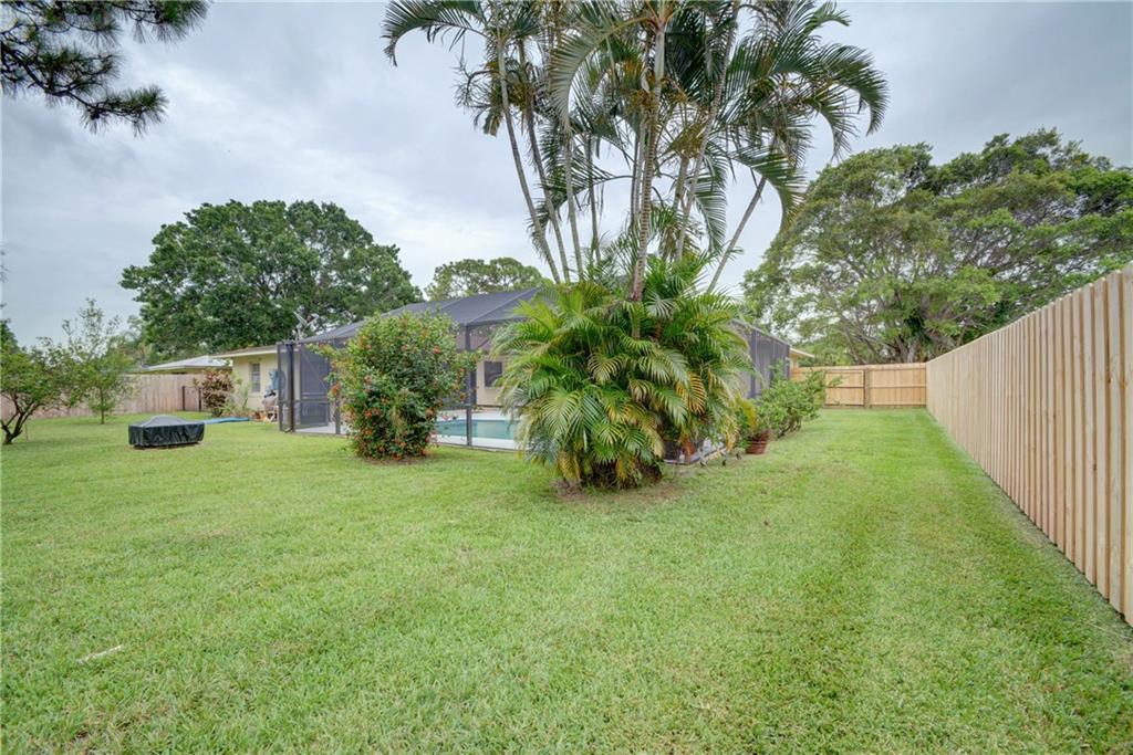 1139 Northwest Fork Road Stuart, FL 34994 - Photo 38 of 43 a view of a backyard with plants and a large tree