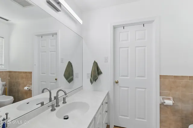 a bathroom with a double vanity sink and a mirror