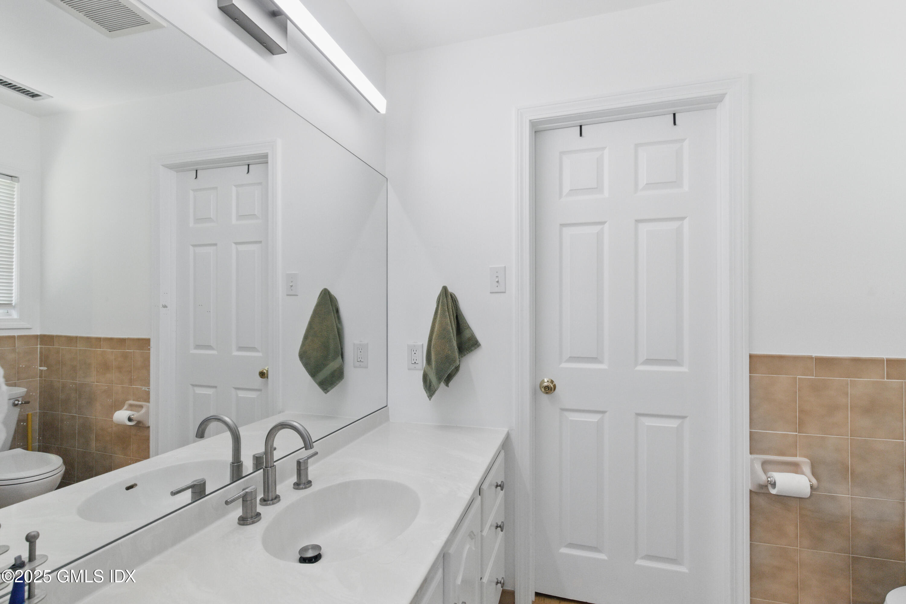 51 Orchard Place Greenwich, CT 06830 - Photo 14 of 18 a bathroom with a double vanity sink and a mirror
