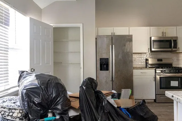 a kitchen with stainless steel appliances granite countertop a refrigerator and a stove top oven