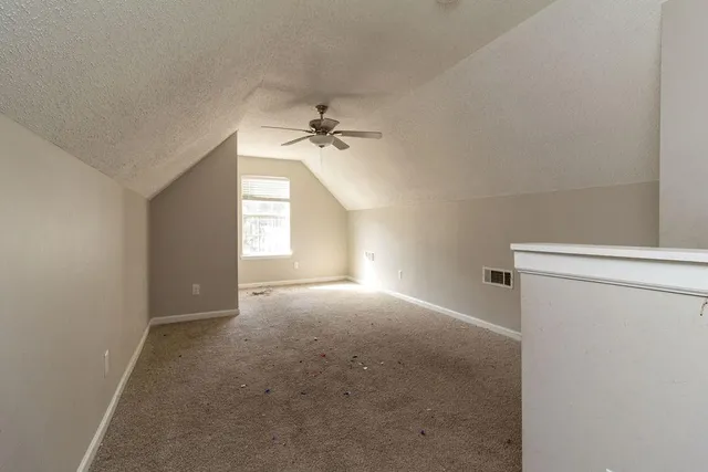 a view of empty room with windows and fan
