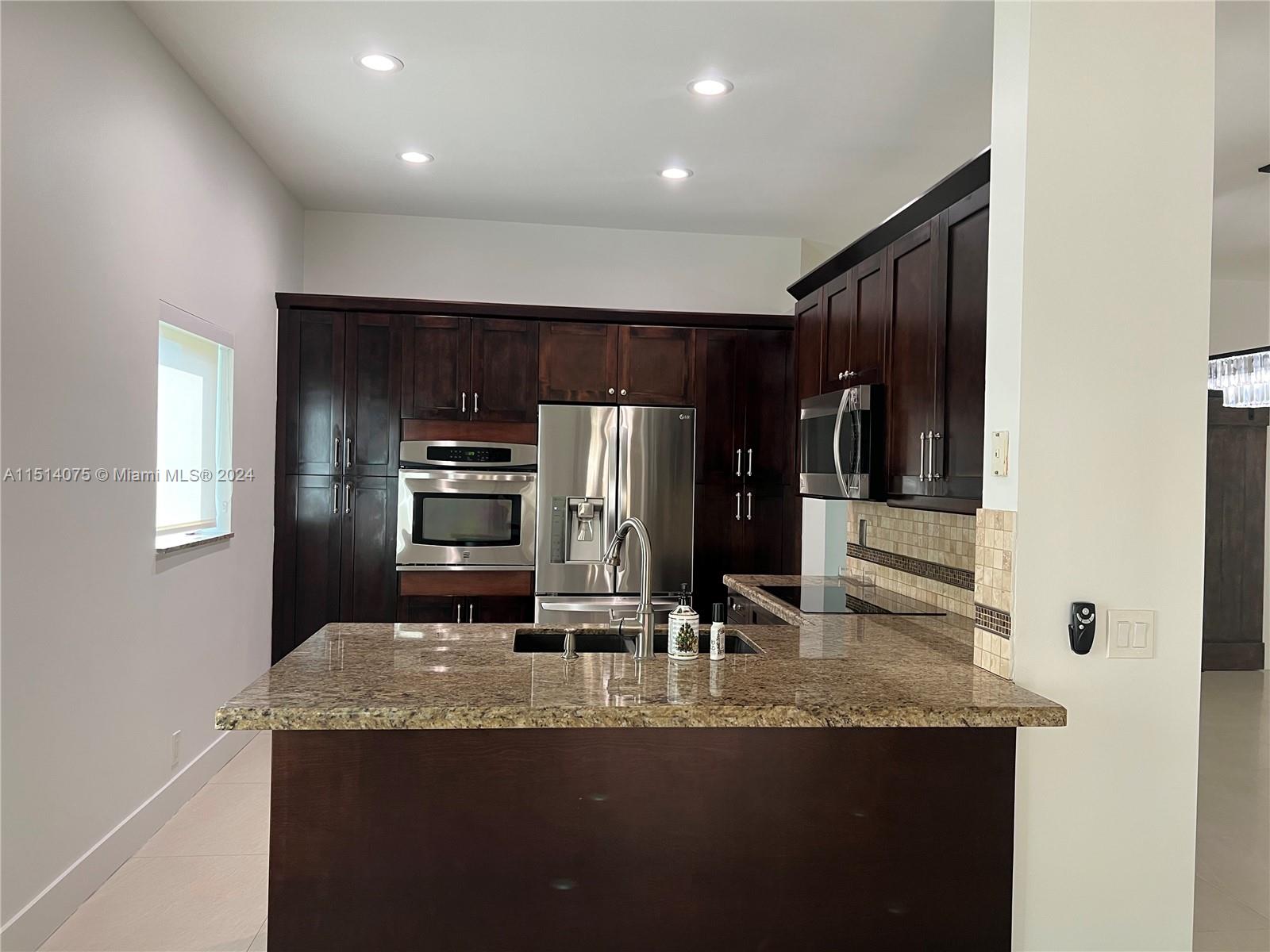 Savanna Weston, FL 33327 - Photo 3 of 26 a kitchen with kitchen island granite countertop a refrigerator and a stove top oven
