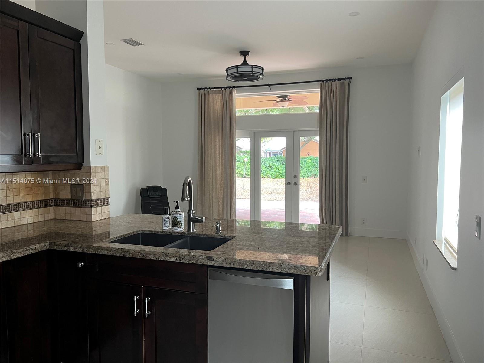 Savanna Weston, FL 33327 - Photo 5 of 26 a kitchen with granite countertop a sink stainless steel appliances and cabinets