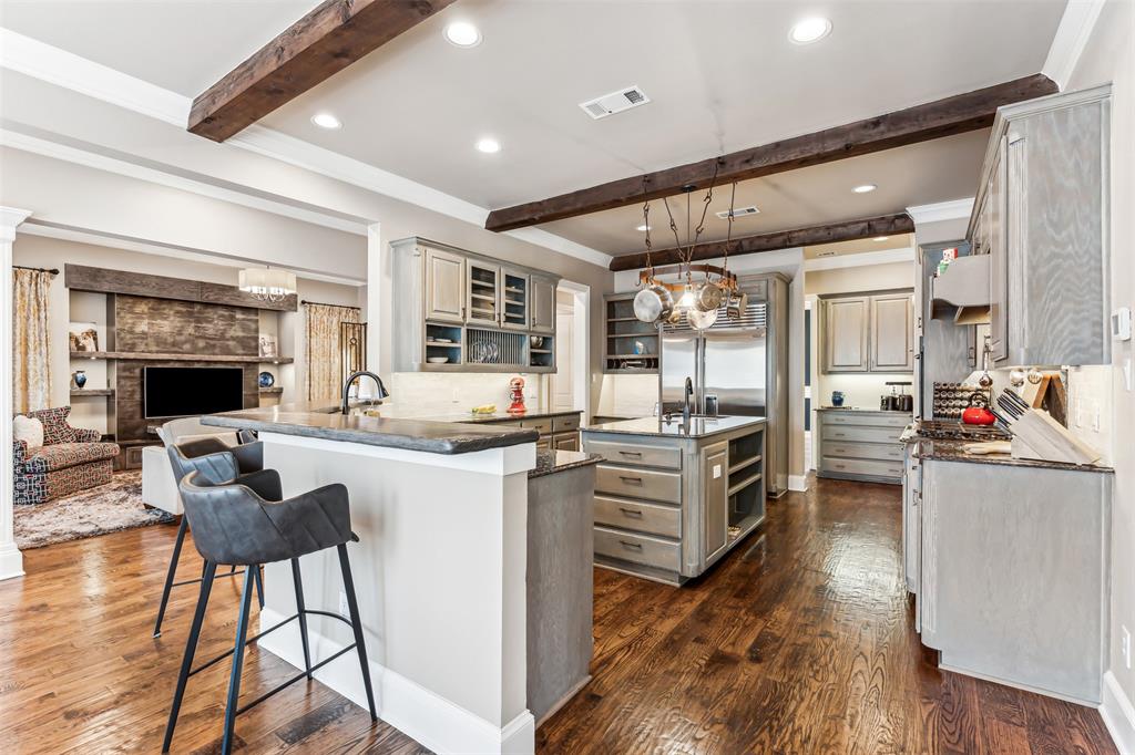 1815 West Forest Grove Road Lucas, TX 75002 - Photo 2 of 40 Kitchen featuring visible vents, dark wood-type flooring, beamed ceiling, a kitchen bar, and gray cabinets