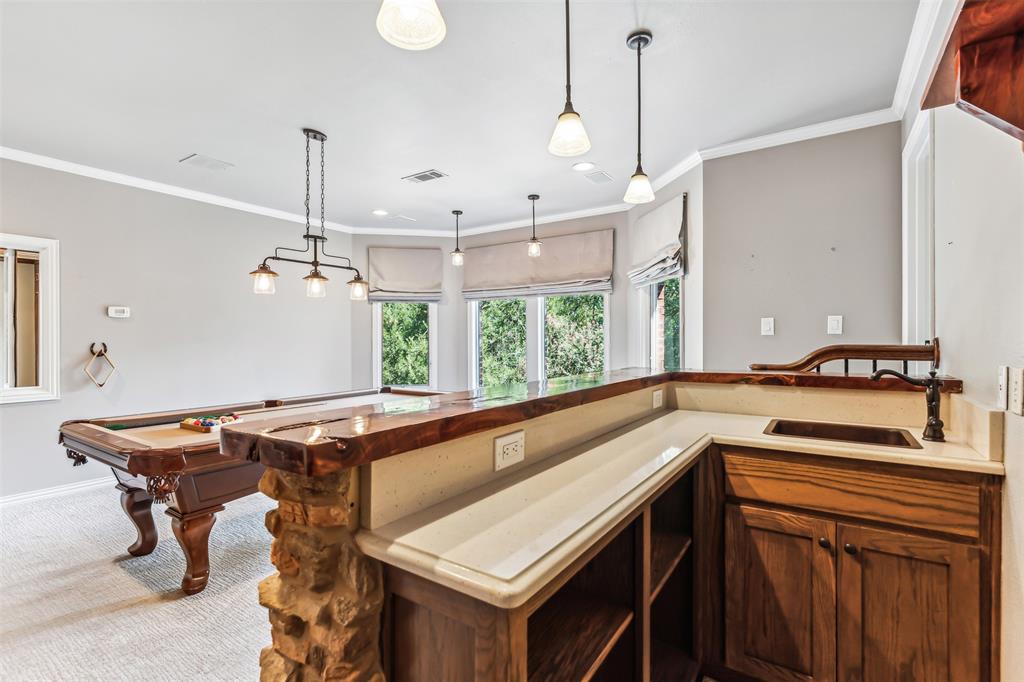 1815 West Forest Grove Road Lucas, TX 75002 - Photo 33 of 40 Kitchen featuring visible vents, a sink, hanging light fixtures, crown molding, and carpet flooring