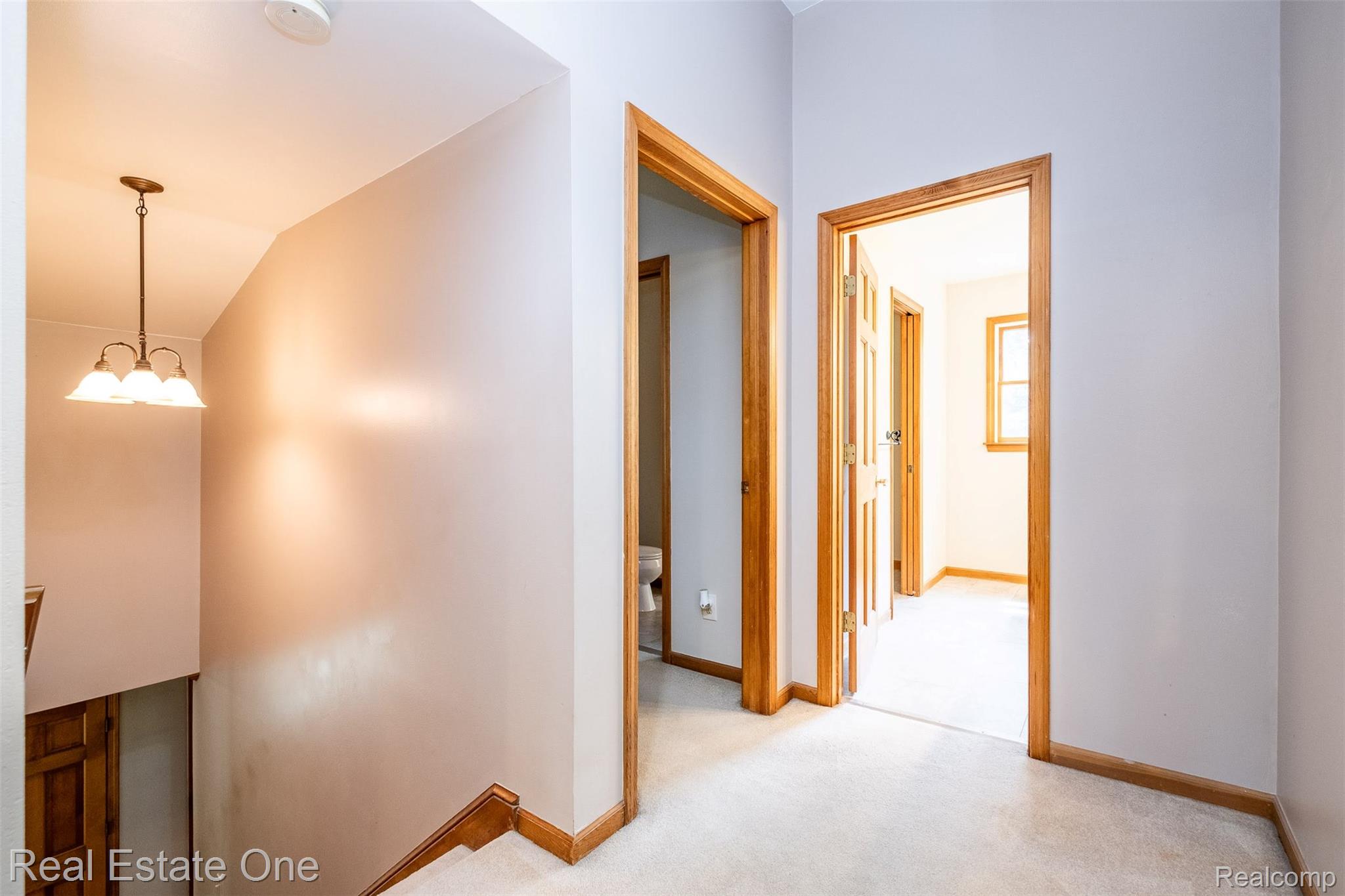 11030 Marshall Road South Lyon, MI 48178 - Photo 44 of 83 Carpeted hallway with wood trim and doors