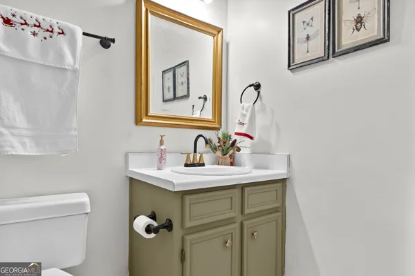 a bathroom with a sink mirror vanity and toilet
