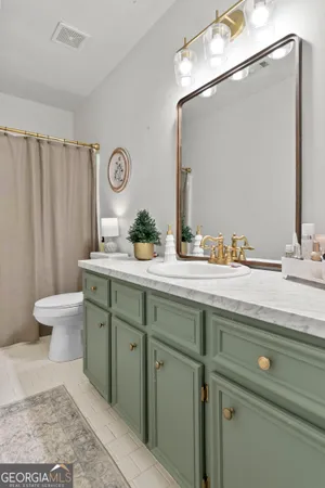 a bathroom with a sink a toilet and a mirror