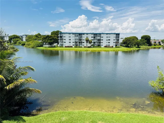 an aerial view of a houses with swimming pool and lake view