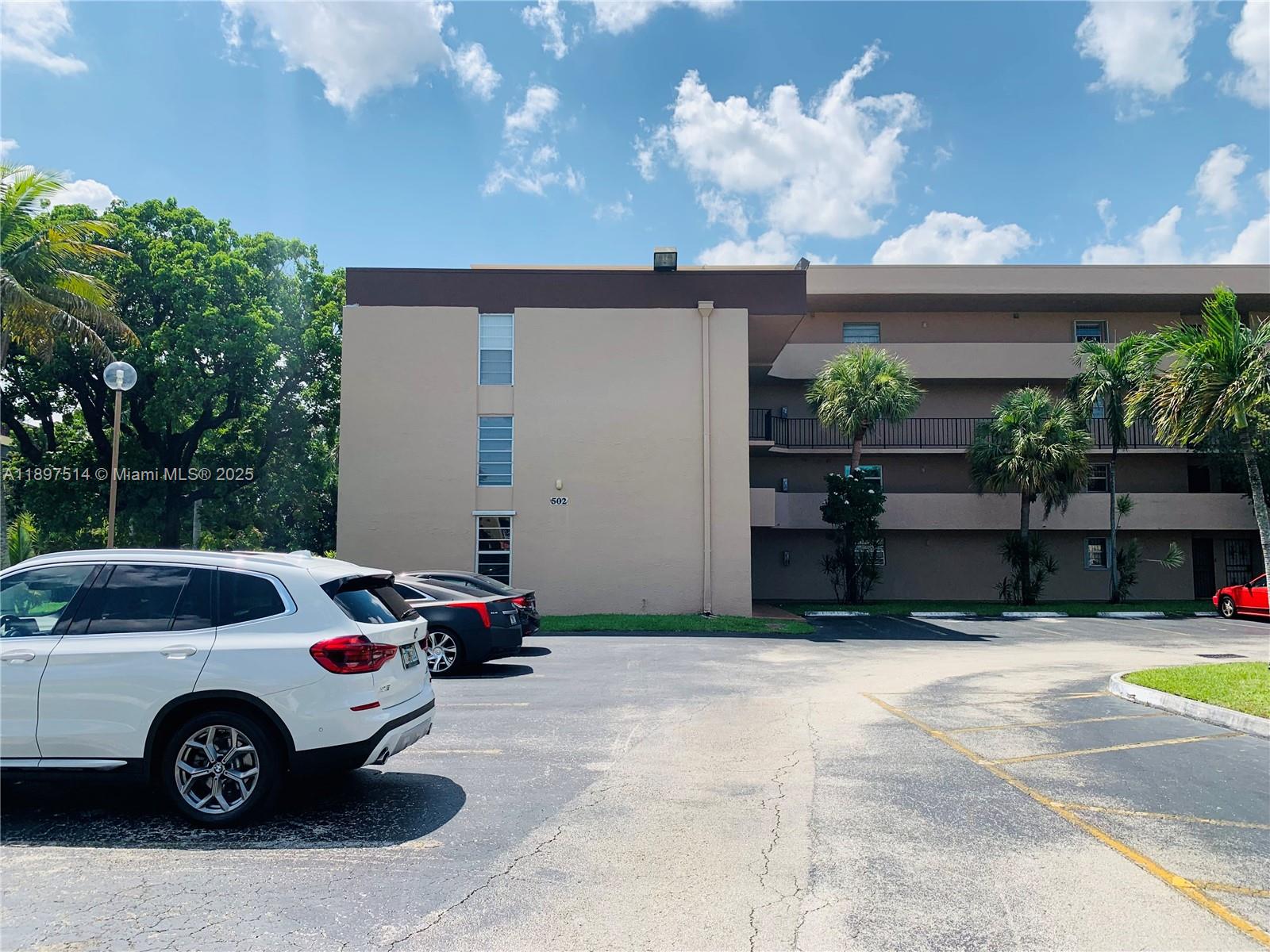 502 Northwest 87th Avenue, Unit 302 Miami, FL 33172 - Photo 12 of 12 a front view of a house with cars parked