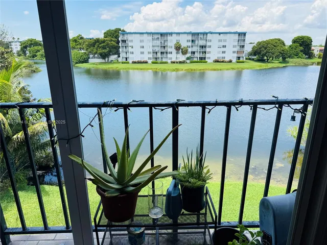 a view of a lake with a floor to ceiling window next to a yard