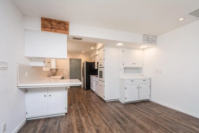 a kitchen with cabinets wooden floor and a sink