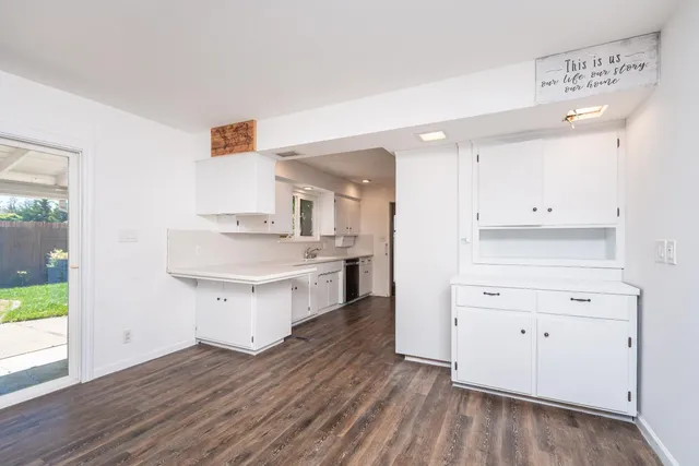 a kitchen with a white cabinets and wooden floor