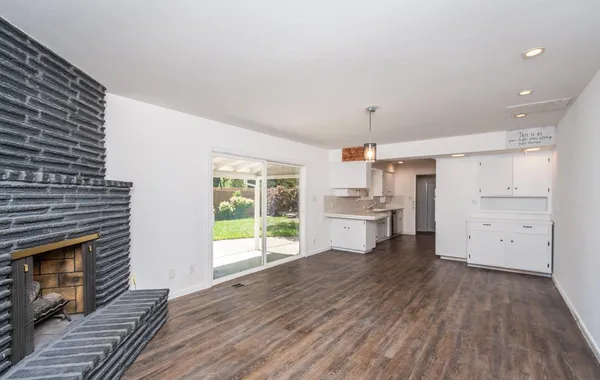 a kitchen with wooden floors and white walls