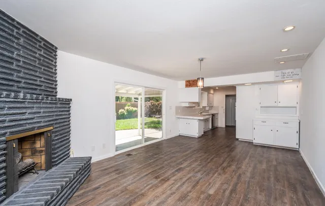 a kitchen with wooden floors and white walls