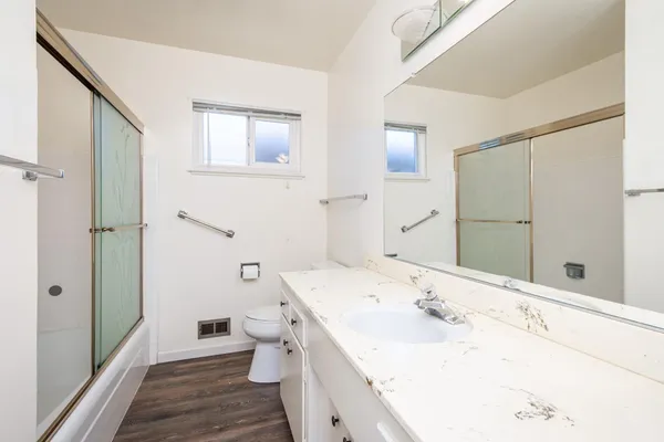 a bathroom with a sink a toilet and shower