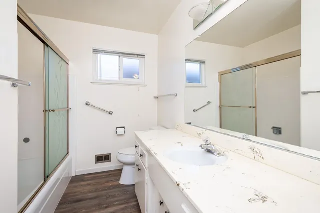 a bathroom with a sink a toilet and shower