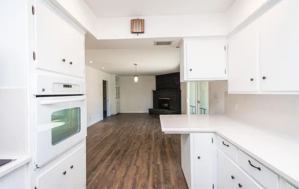 a kitchen with a wooden floor and a stove top oven