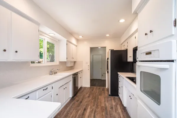 a kitchen with white cabinets and stainless steel appliances