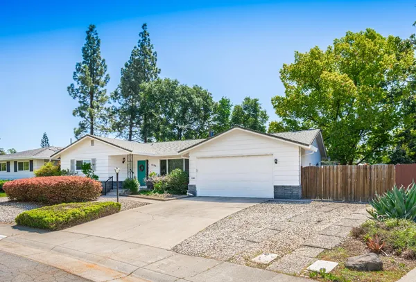 a front view of a house with a garden and yard