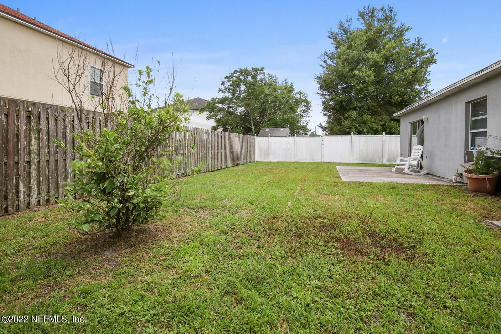 7354 High Bluff Road North Jacksonville, FL 32244 - Photo 25 of 26 a view of a backyard with table and chairs and wooden fence