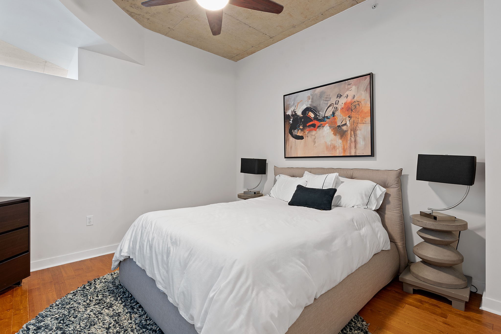 360 Nueces Street, Unit 1310 Austin, TX 78701 - Photo 16 of 40 a bedroom with a bed and a lamp