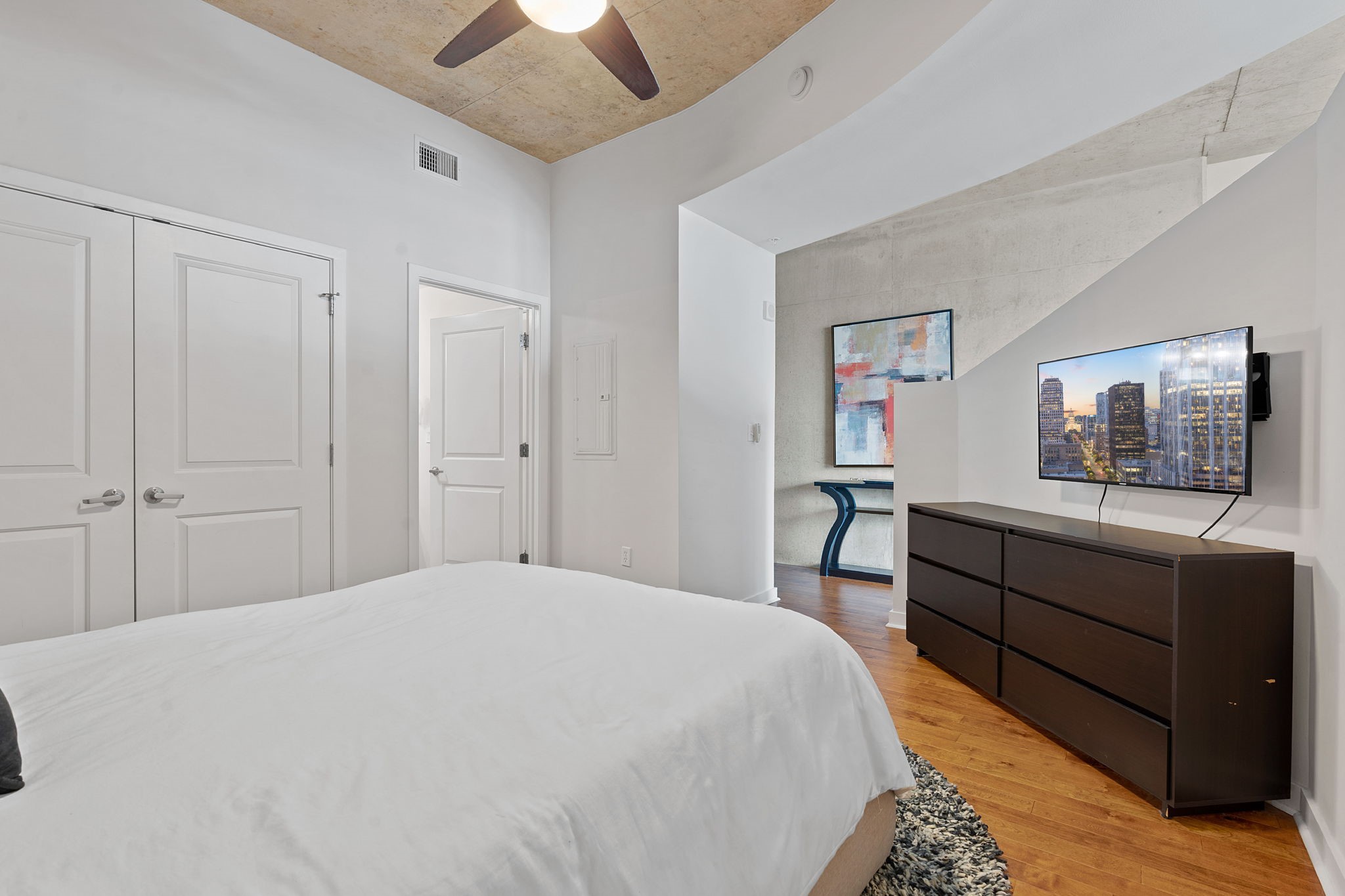 360 Nueces Street, Unit 1310 Austin, TX 78701 - Photo 17 of 40 a bedroom with a bed and a chandelier