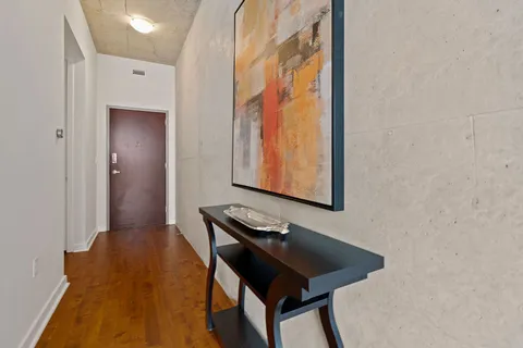 a view of a hallway with furniture and wooden floor