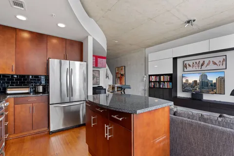 a kitchen with stainless steel appliances granite countertop a refrigerator a sink and a stove