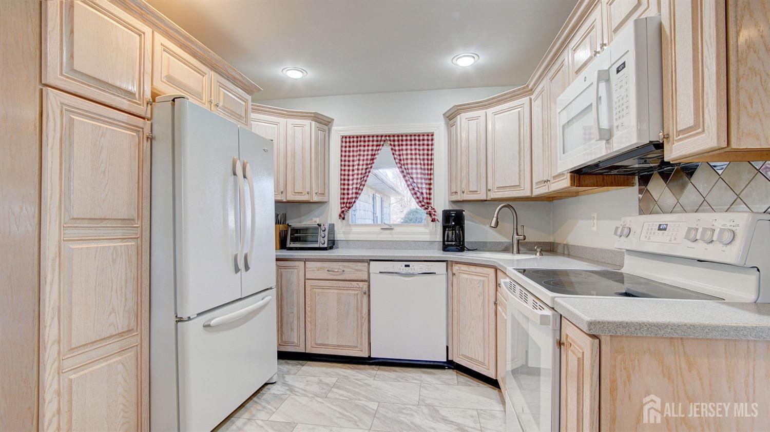 38 Mistletoe Drive Old Bridge, NJ 07747 - Photo 17 of 41 a kitchen with white cabinets and refrigerator