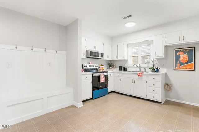 a kitchen with white cabinets and white appliances