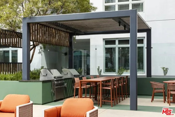 a backyard of a house with barbeque oven table and chairs