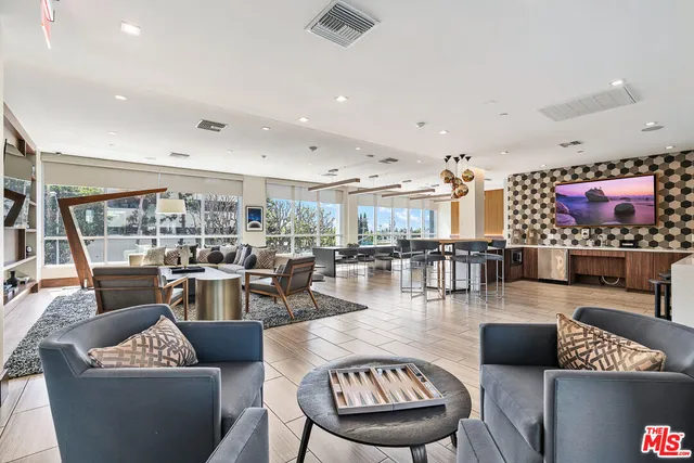 a living room with furniture and a view of kitchen