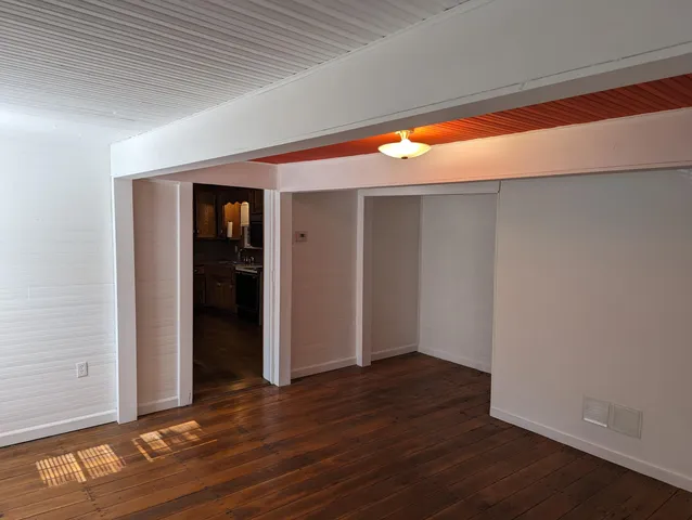 an empty room with wooden floor and closet