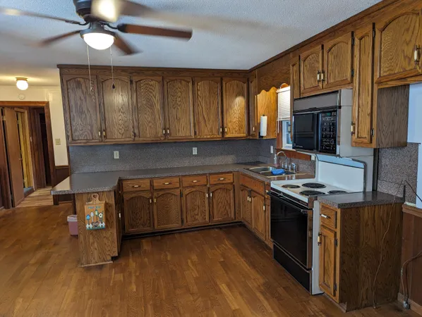 a kitchen with granite countertop a stove and a wooden cabinets