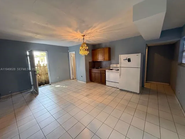a kitchen with a refrigerator a stove top oven and cabinets