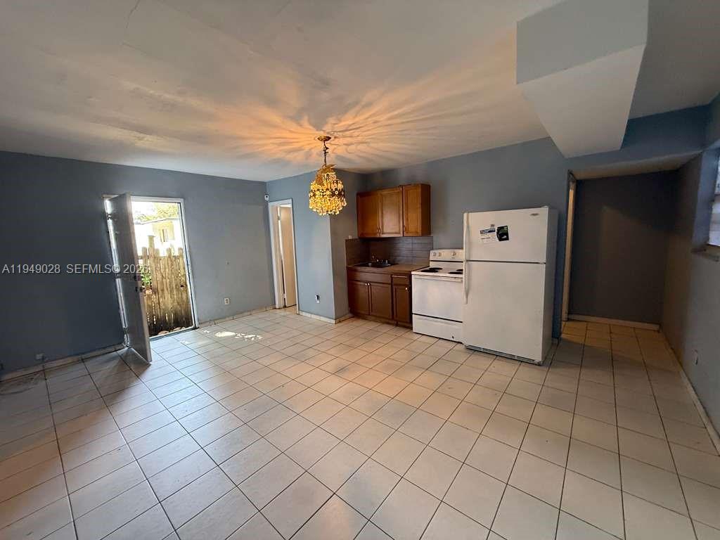 8201 Northwest 5th Court, Unit BACK Miami, FL 33150 - Photo 3 of 9 a kitchen with a refrigerator a stove top oven and cabinets