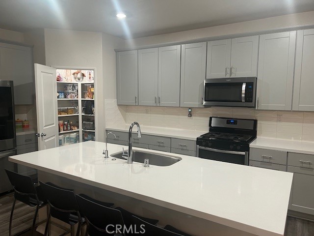 29901 Bridlegate Way Menifee, CA 92584 - Photo 13 of 43 a kitchen with stainless steel appliances a stove a sink and a microwave
