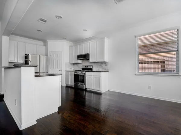 a kitchen with stainless steel appliances a refrigerator sink and white cabinets