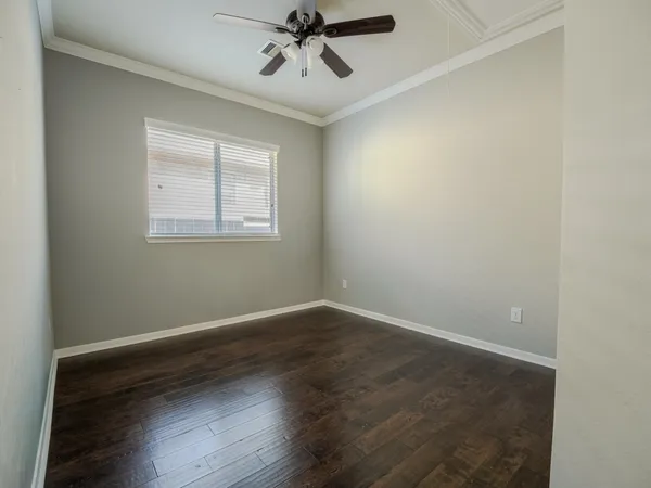 an empty room with wooden floor and a window