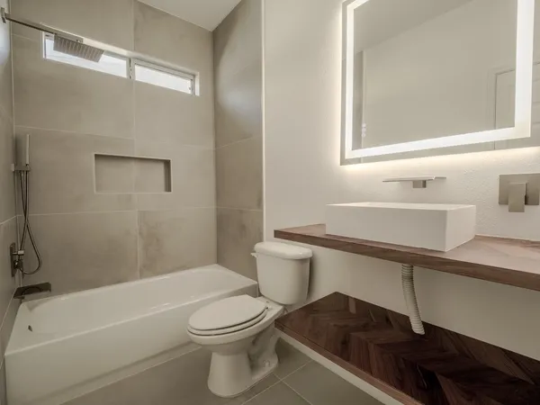 a bathroom with a sink a toilet and a mirror